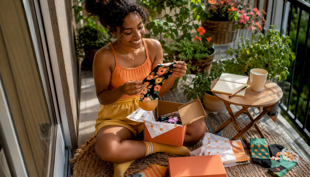 Woman unpacking UK sock subscription box at kitchen table