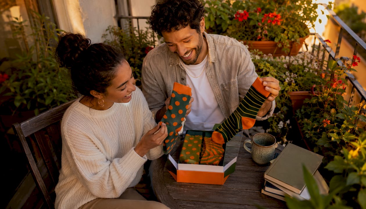 Couple examining his and hers sock sets at home